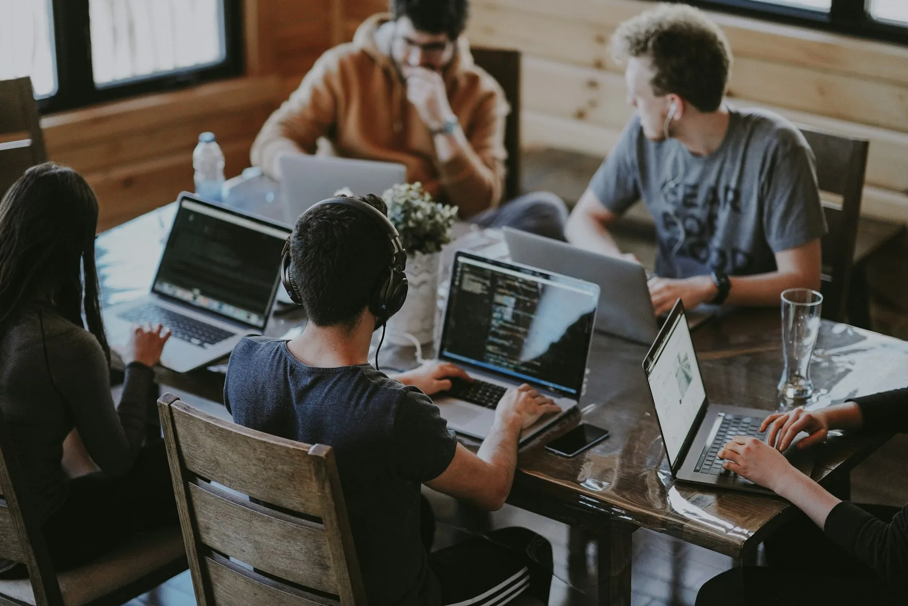 Founders collaborating around laptops in a bright studio