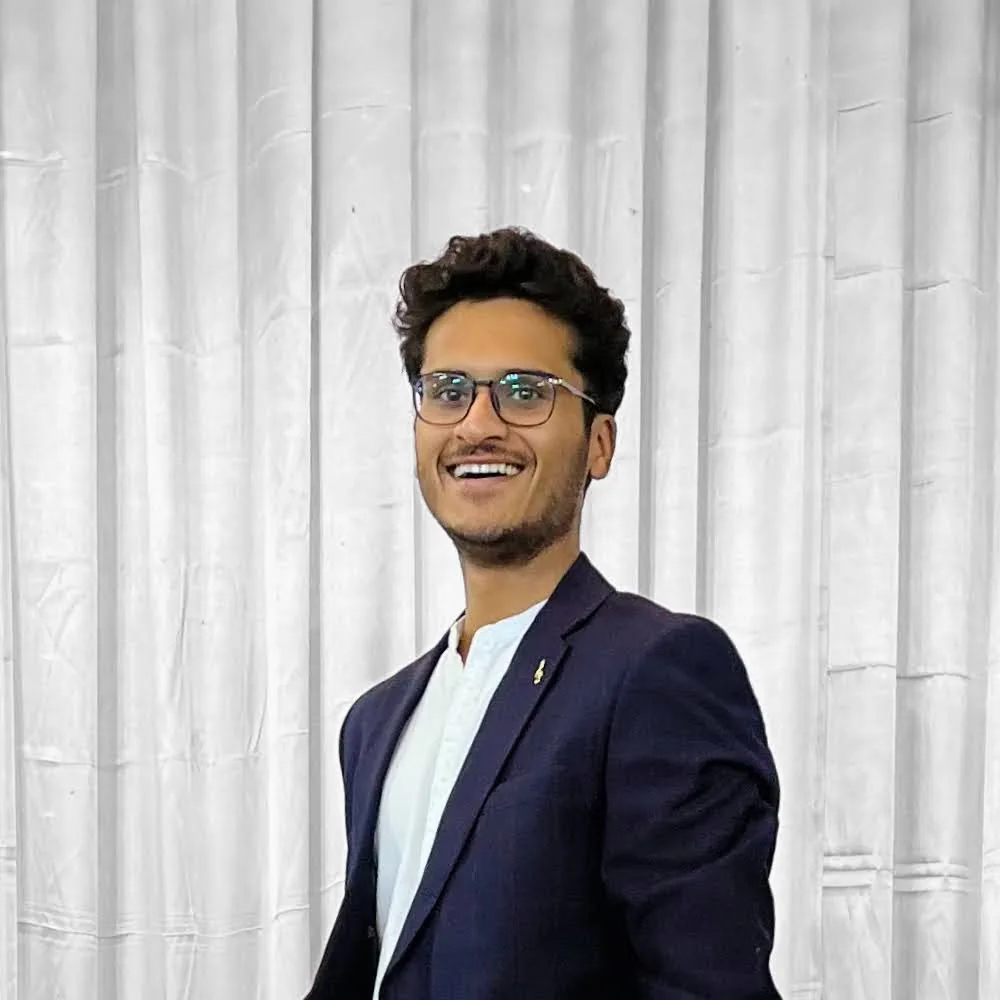 Nitesh Oswal, smiling in a navy blazer